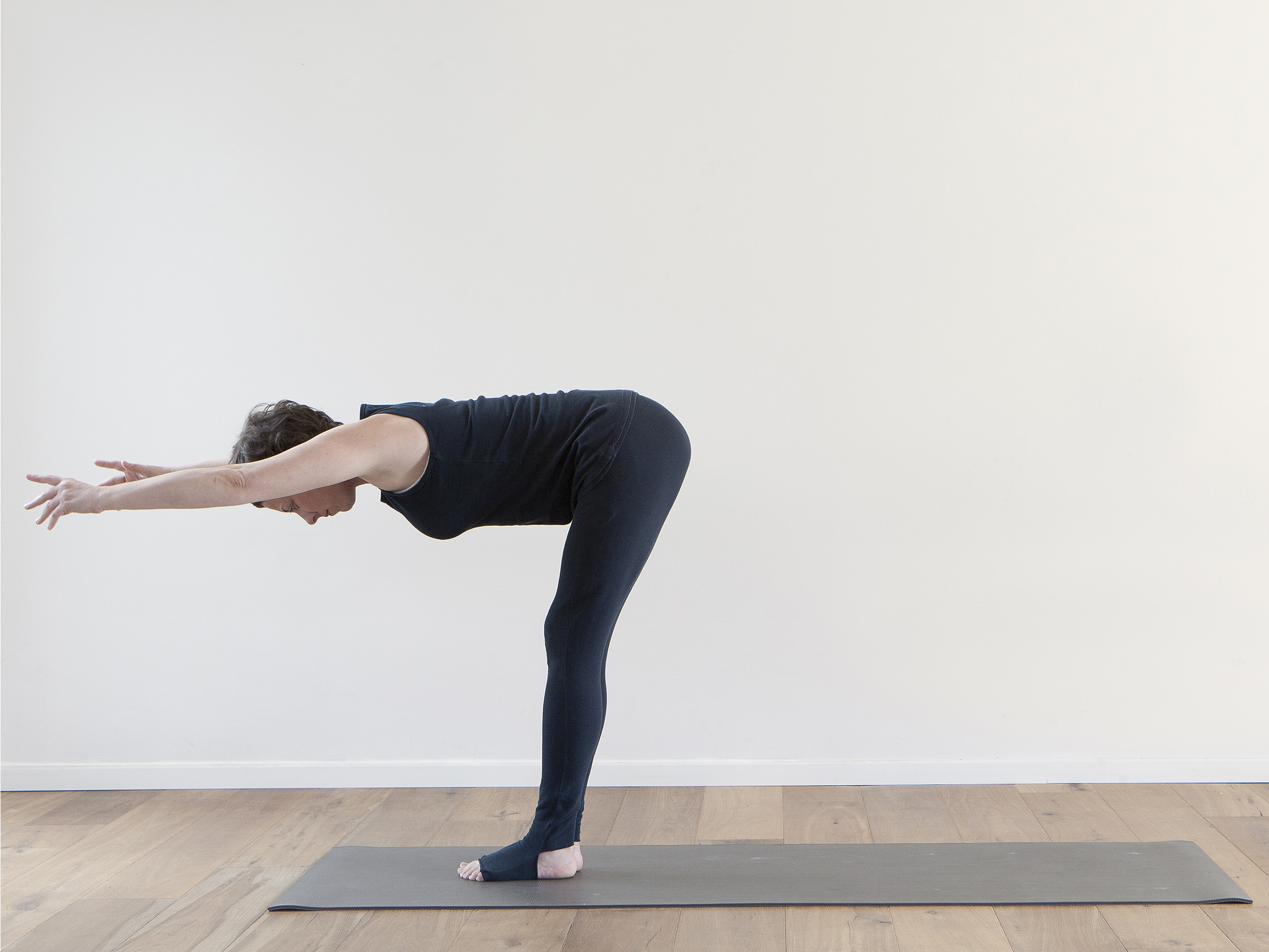 תנוחת "ר" עומדת כנגד הקיר, מאפשרת הארכת החלק האחורי של הגוף וריווח בין חוליות עמוד השדרה. התנוחה מתבצעת תוך השתרשות הידיים אל הקיר והרגליים אל הרצפה כך שמתקיים פה "מעגל שרירים סגור" התומך בייצוב הגוף ובערור שרירי הליבה לעבוד יחד לתמיכה מירבית- פנימית וחיצונית. 